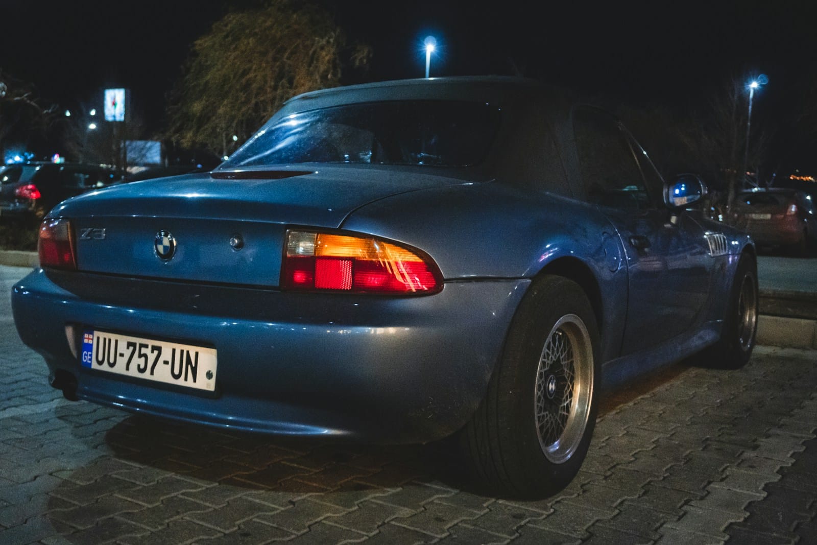 a blue sports car parked on the side of the road