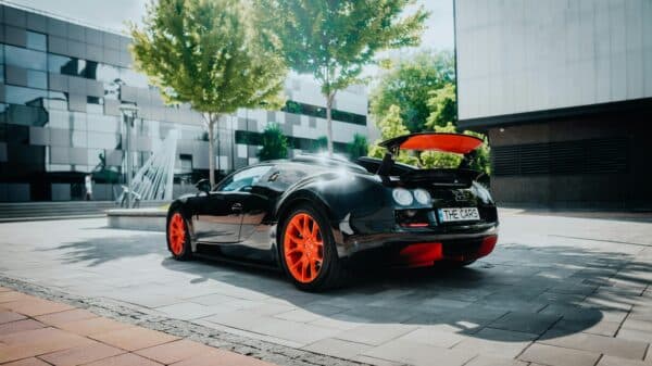 a black sports car with orange rims parked on a street