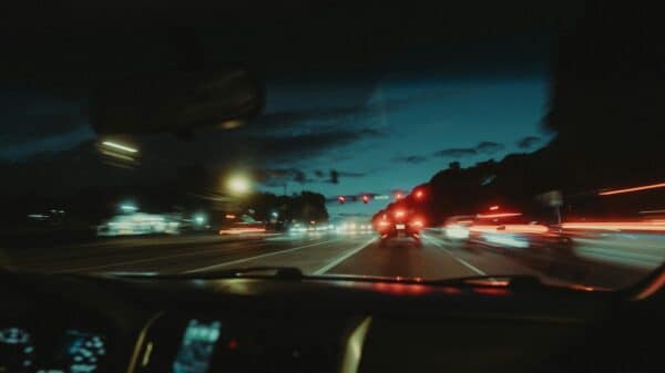 a car driving down a street at night