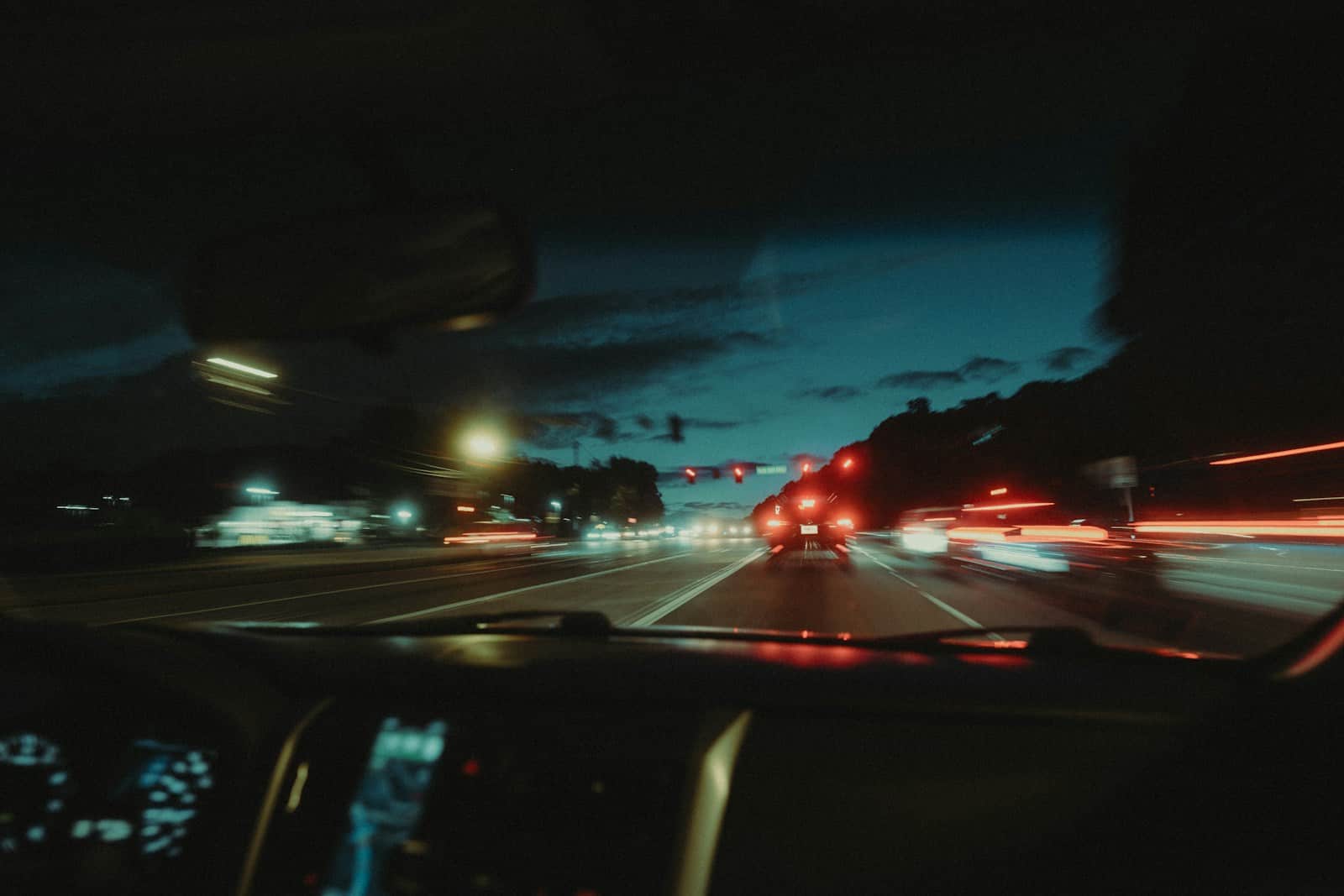 a car driving down a street at night