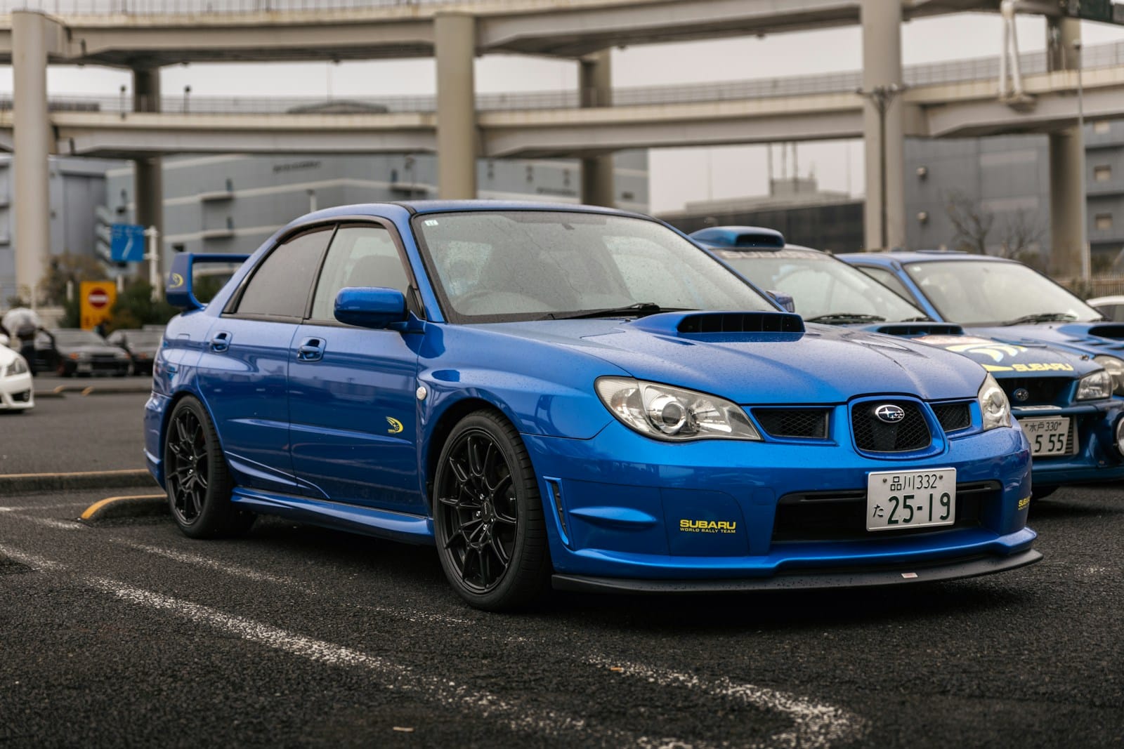 A blue subaru wrx sti parked in a lot.