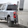 A silver truck parked on a gravel road