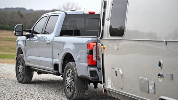 A silver truck parked on a gravel road