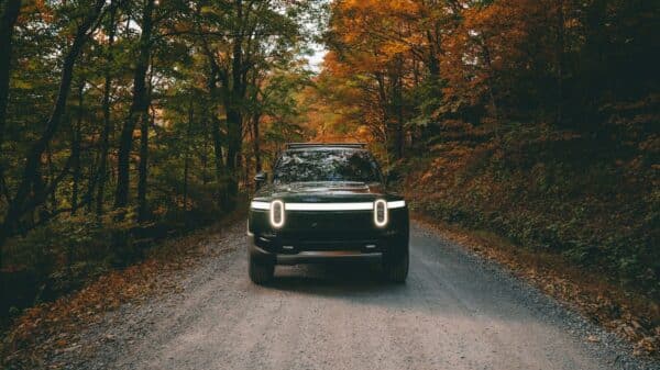 a car on a dirt road surrounded by trees