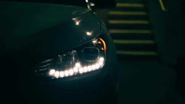 a close up of a car's headlight with stairs in the background