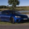 a blue car parked by a lake