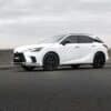 A white lexus suv is parked on the road.