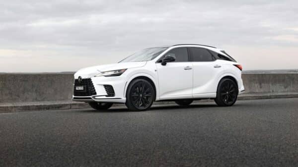 A white lexus suv is parked on the road.