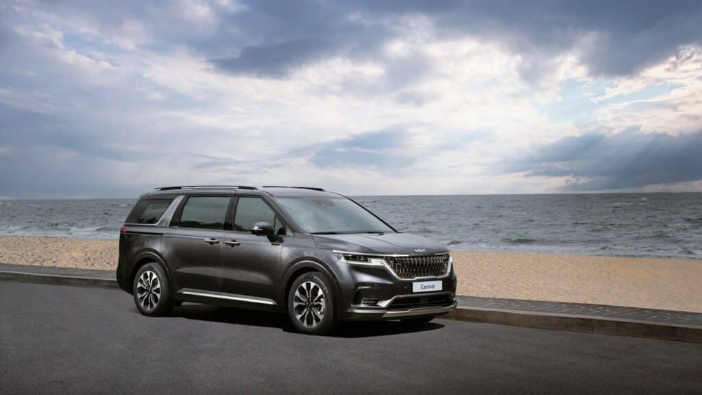 a grey suv parked on the side of a road near the ocean