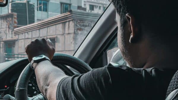 man in black shirt driving car during daytime