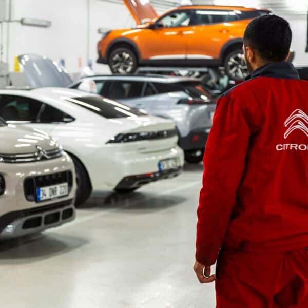 A man standing in a garage looking at cars