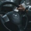 person holding black nissan steering wheel