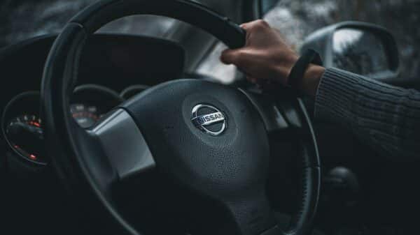 person holding black nissan steering wheel