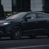 A black lamborghini urus suv parked on the street.