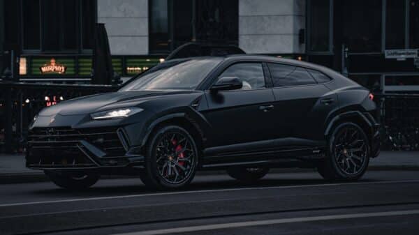 A black lamborghini urus suv parked on the street.