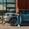 a woman standing next to a blue car