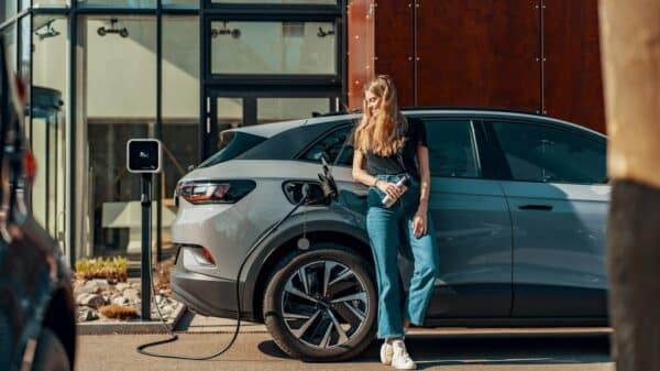a woman standing next to a blue car