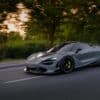 a silver sports car driving down a street