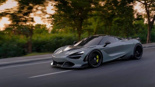 a silver sports car driving down a street