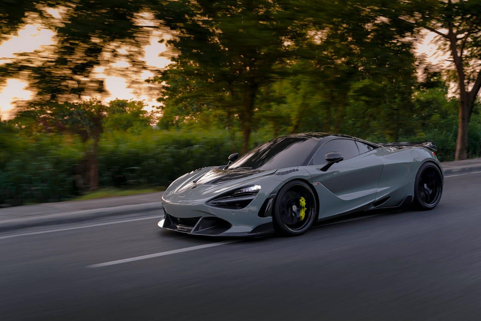 a silver sports car driving down a street