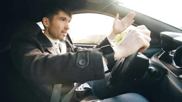 Man driving a car, gesturing with hand