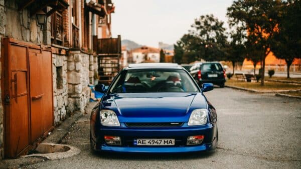 Blue sports car parked on a street with old buildings