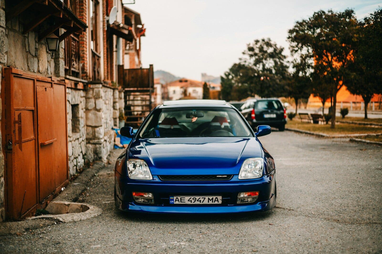 Blue sports car parked on a street with old buildings