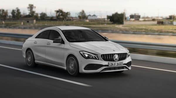 a white mercedes cla driving down a highway