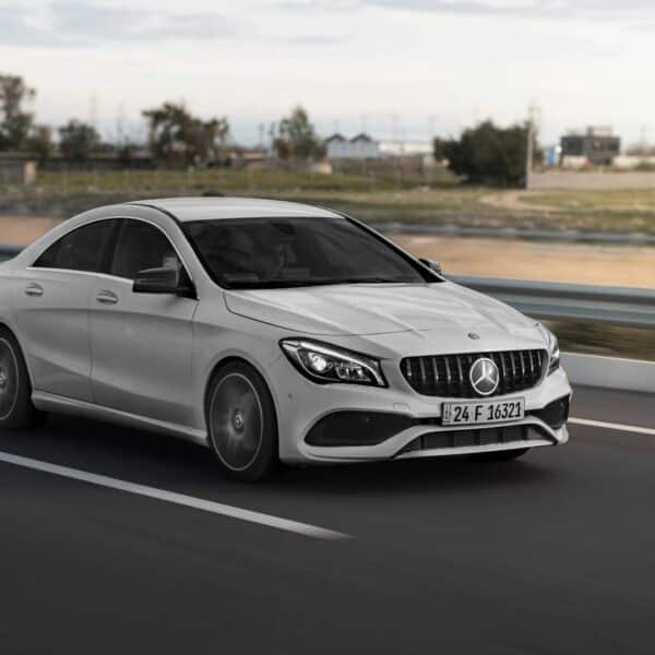 a white mercedes cla driving down a highway
